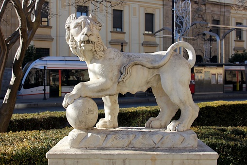 White lion with the ball, street sculpture in the old town, Seville, Spain - January 5, 2019