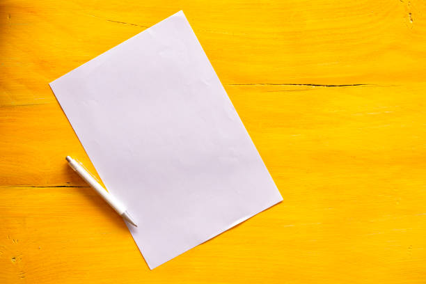 Blank A4 paper on yellow wooden background. Shot with dslr camera canon 5dsr