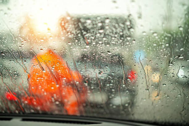 street in the heavy rain. water drops or rain in front of mirror of car on road or street. driving in rain. blurred background. - highway street road speed imagens e fotografias de stock