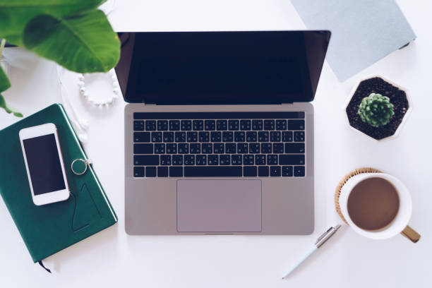 istock Top view of modern laptop or notebook with phone to work. Office desktop on table background. 1300927880