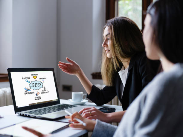 search engine optimization (seo) concept op computerscherm met twee zakenvrouwen in het kantoor - zoekmachine stockfoto's en -beelden