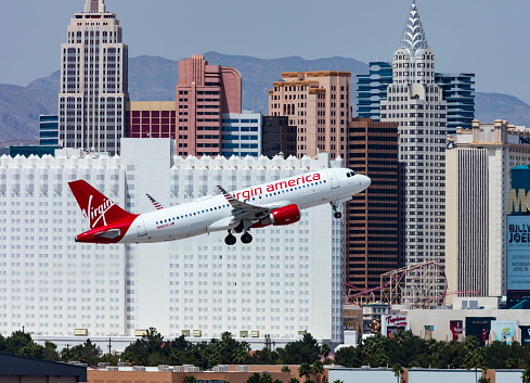 Las Vegas, Nevada, USA - April 21 2016: A Virgin America Airbus A320 takes of from McCarran International Airport. The hotels on the Vegas Strip can be seen in the background.
