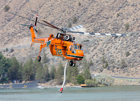 Madras, Oregon, USA - August 29, 2015: An Erickson Air-Crane S-64, named Delilah, fills its water tank from Lake Billy Chinook during firefighting operations just southeast of Madras, Oregon.
