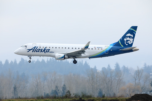 Portland, Oregon, USA - January 29, 2021: An Alaska Airlines Embraer 175 operated by SkyWest Airlines lands at Portland International Airport.