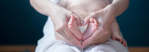 Baby feet in mother hands Baby feet in mother hands. Tiny Newborn Baby's feet on female Heart Shaped hands closeup. Mom and her Child. Happy Family concept. Beautiful conceptual image of Maternity. Shot with dslr camera, canon 5dsr 8 months pregnant stock pictures, royalty-free photos & images