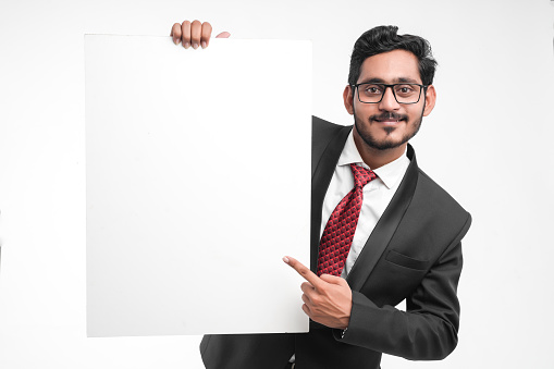 Young indian business man holding blank sign board