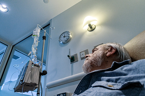 Senior Man Cancer Patient Looking at Chemotherapy Medicine photo