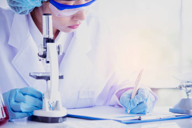 istock Female scientist look at microscope, science test tube analyse scientific sample in laboratory research experiment biotech make cultivate vaccine against virus. Chemistry science laboratory concept 1300934663