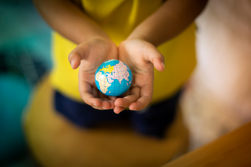 Little hand holding the globe. Earth day. Green concept