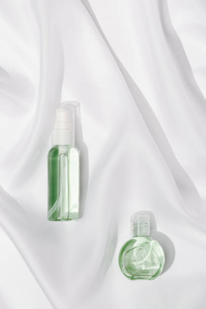 istock Cosmetic product in transparent plastic bottle with beautiful shadows on white silk cloth texture background. 1300938116