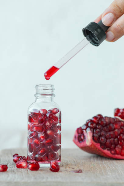 istock Woman Dripping Pomegranate Seed Oil 1300939245