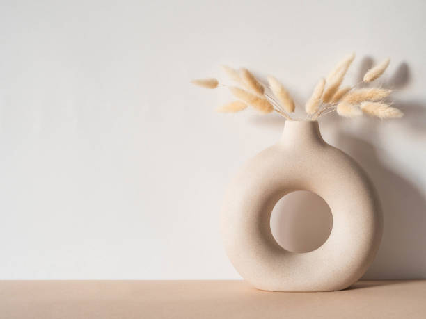 Round stylish ceramic vase with dried flower lagurus stock photo