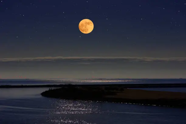 Photo of Full moon rising over the Tokyo bay area
