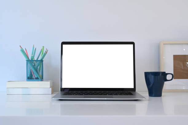 istock Laptop computer with empty screen, books, coffee cup and stationery on white table. 1300943123