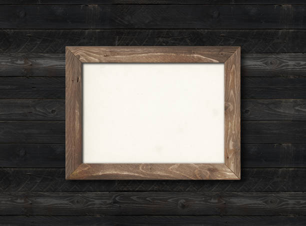 istock Old rustic wooden picture frame hanging on a black wall. Horizontal picture 1300943337