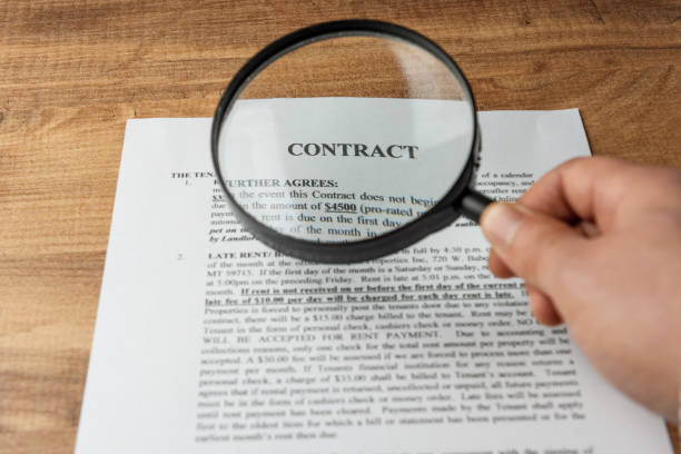 businessman examines the contract with magnifying glass - condition text magnifying glass contract imagens e fotografias de stock