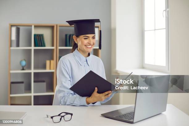 Happy Graduate Sitting At Laptop Computer And Presenting Her Thesis Remotely Via Video Call Stock Photo - Download Image Now