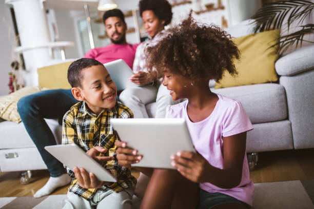 istock African american boy and girl lying on floor and using digital tablet. 1300946869