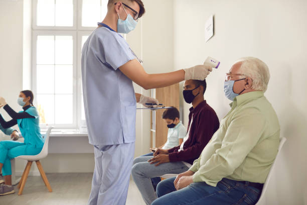istock Medical worker taking senior man's temperature using non-contact electronic thermometer 1300947168