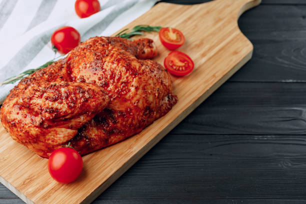 istock One half of grilled chicken on wooden cutting board 1300947773