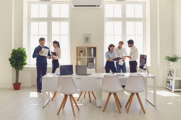 istock Young people work with documents, smile and talk to each other in a bright office. 1300948040