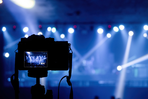 Concept of production in pubs and concert events, camera shooting beams from spotlights and lights in blue tones.