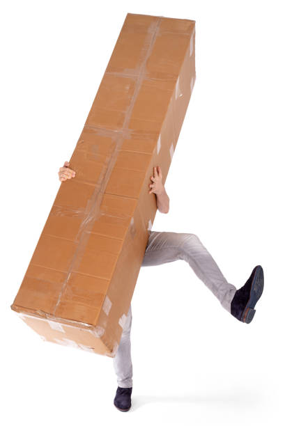 istock Man carrying a oversized cardboard box, isolated on white 1300952846
