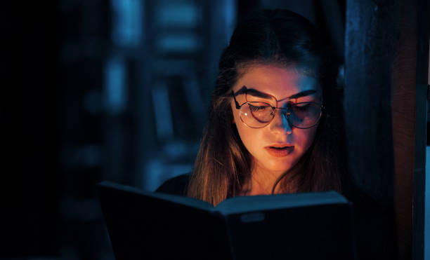 istock Light goes from the book. Female student is in library. Conception of education 1300957525
