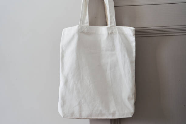 istock White eco friendly bag hanging on the door handle. Canvas tote bag 1300957859