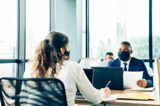 istock Corporate professionals working in office during pandemic 1300958364