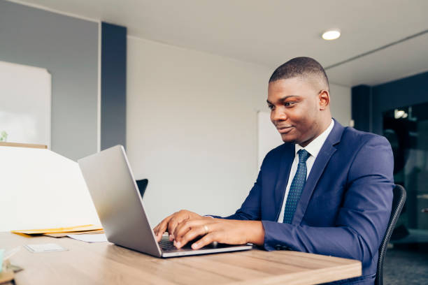 istock Confident businessman using laptop at desk 1300958413