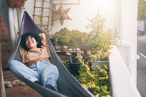 Shot of a young woman relaxing on a hammock outdoors