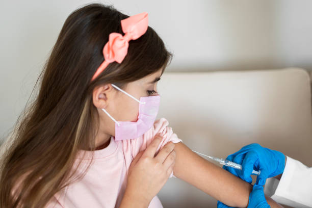 小さな女の子にコビッドワクチンを与える医師 - little girls vaccination child caucasian ストックフォトと画像