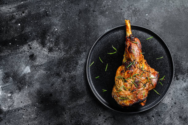 istock Oven baked lamb leg.  Dark background. Top view. Copy space 1300960783