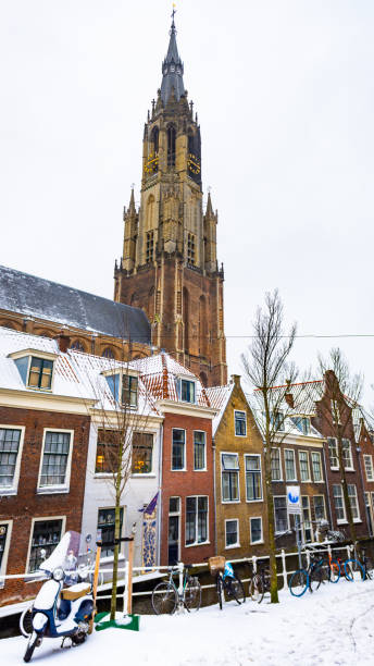 Delft, Netherlands - Snow in the city center with a canal in downtown, church and traditional dutch houses Old city center of Delft (Zuid-Holland, Netherlands). View of the canal (Voldersgracht) with tipical dutch houses. Behind the houses is the''Nieuwe Kerk''. delft winter netherlands snow stock pictures, royalty-free photos & images