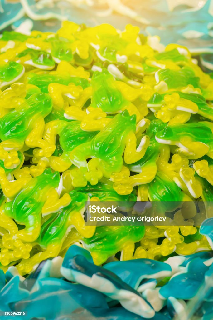Green and yellow gummy candy frog and blue sharks Eating Stock Photo