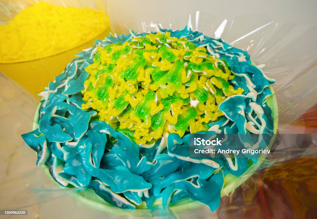 Green and yellow gummy candy frog and blue sharks Shark Stock Photo