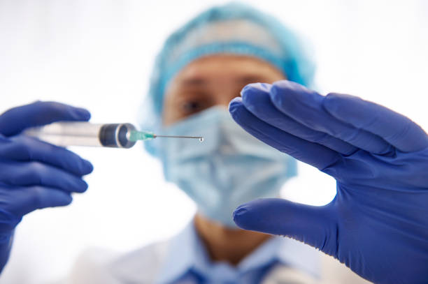 istock Doctor with syringe ready to vaccinate population isolated on white background. Vaccination day. Fighting Infectious Diseases. 1300962363