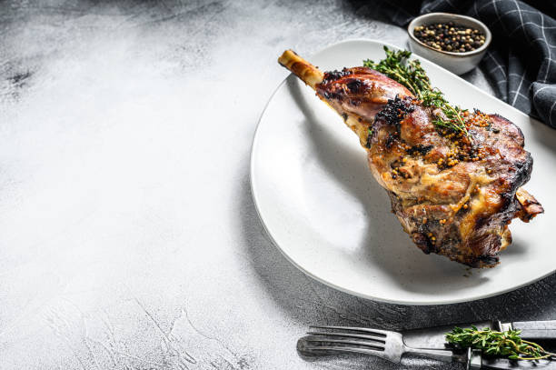istock BBQ lamb leg with herbs. Gray background. Top view. Copy space 1300962442