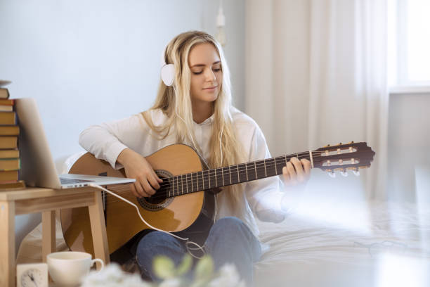 istock Gir Learning to Play Guitar at Home 1300965038