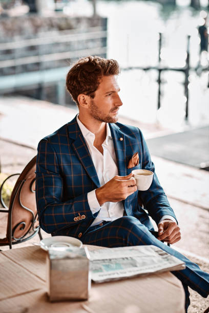 istock Handsome man reading newspaper in cafe 1300966479