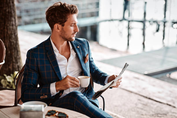 Handsome man reading newspaper in cafe