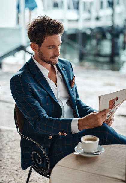 istock Handsome man reading newspaper in cafe 1300966740