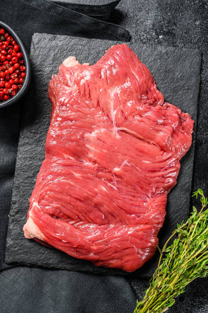 istock Raw flank steak, marbled meat. Black background. Top view. Copy space 1300966806