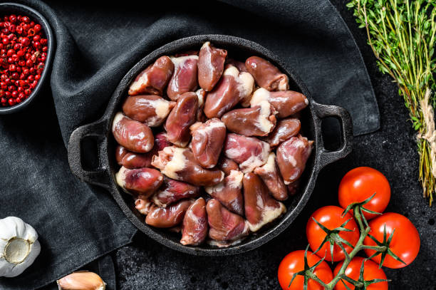 istock Fresh chicken hearts. Raw offal. Black background. Top view 1300968133