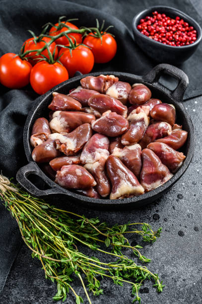 istock Fresh chicken hearts. Raw offal. Black background. Top view 1300968153