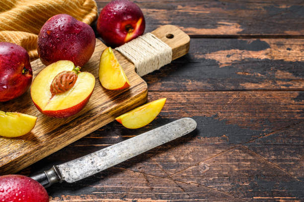 istock Sliced ripe red nectarines on a chopping Board. Dark Wooden background. Top view. Copy space 1300968458