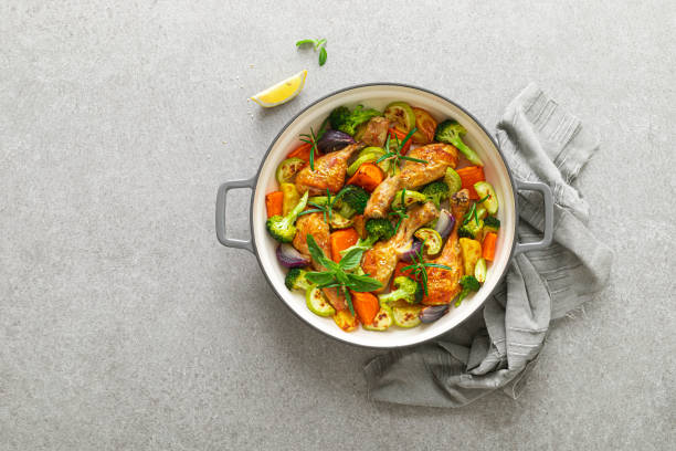 istock Chicken drumsticks roasted with vegetables in cast iron pan on kitchen table. Top view 1300969226