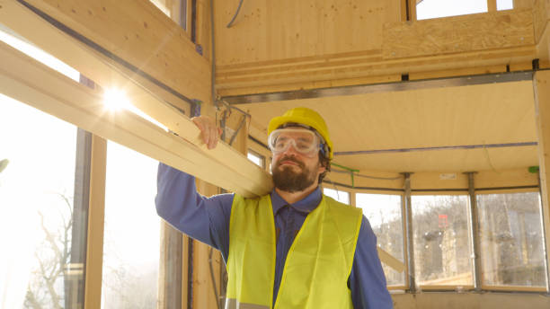 istock CLOSE UP: Worker arrives to work carrying heavy wooden beams on his shoulder 1300969966