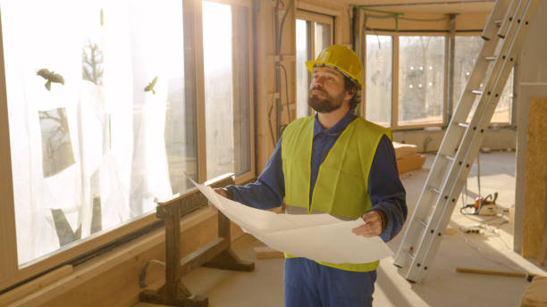 istock LENS FLARE: Contractor holding the construction plans looks at unfinished house. 1300970029